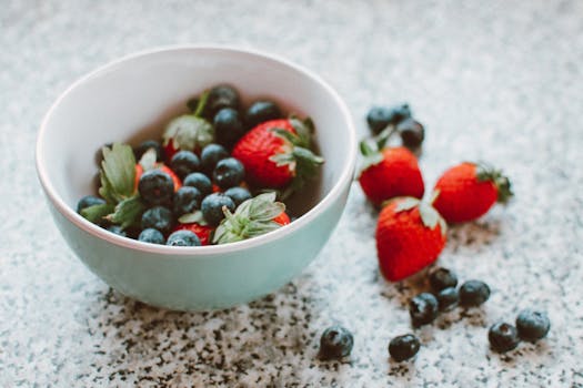 A bowl of mixed berries on a kitchen counter